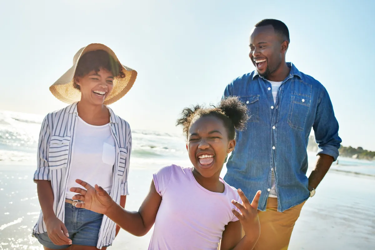Happy family laughing together on a sunny beach