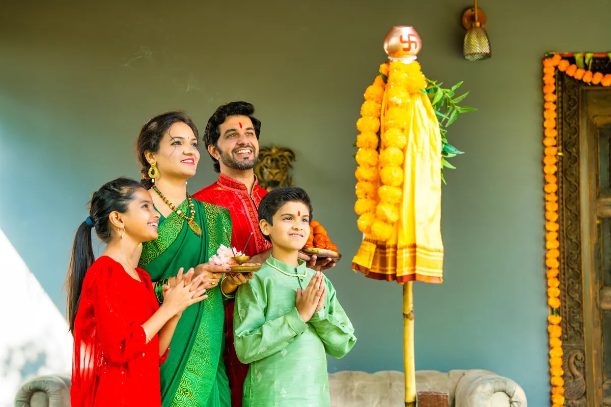 Indian family in festive traditional clothes celebrating together at home