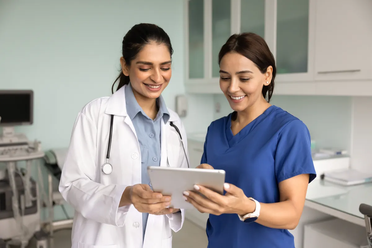 Nurse and doctor reviewing a tablet in a bright clinic