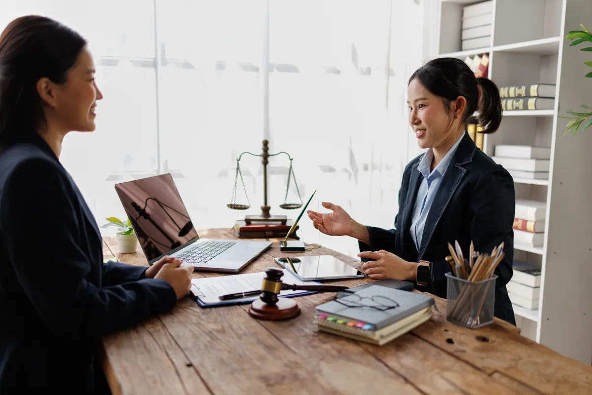 Adviser consulting a client across a desk in a bright office