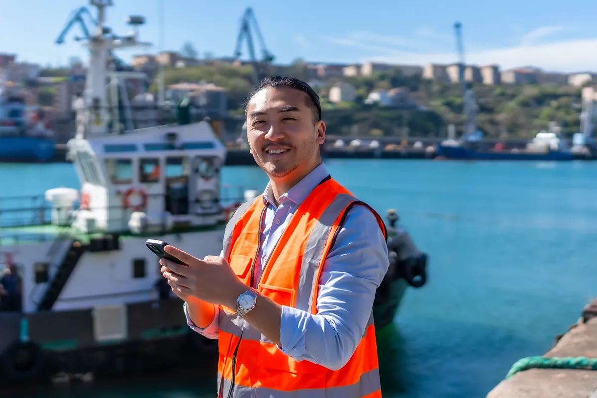 Port worker with a tablet at a sunny harbour