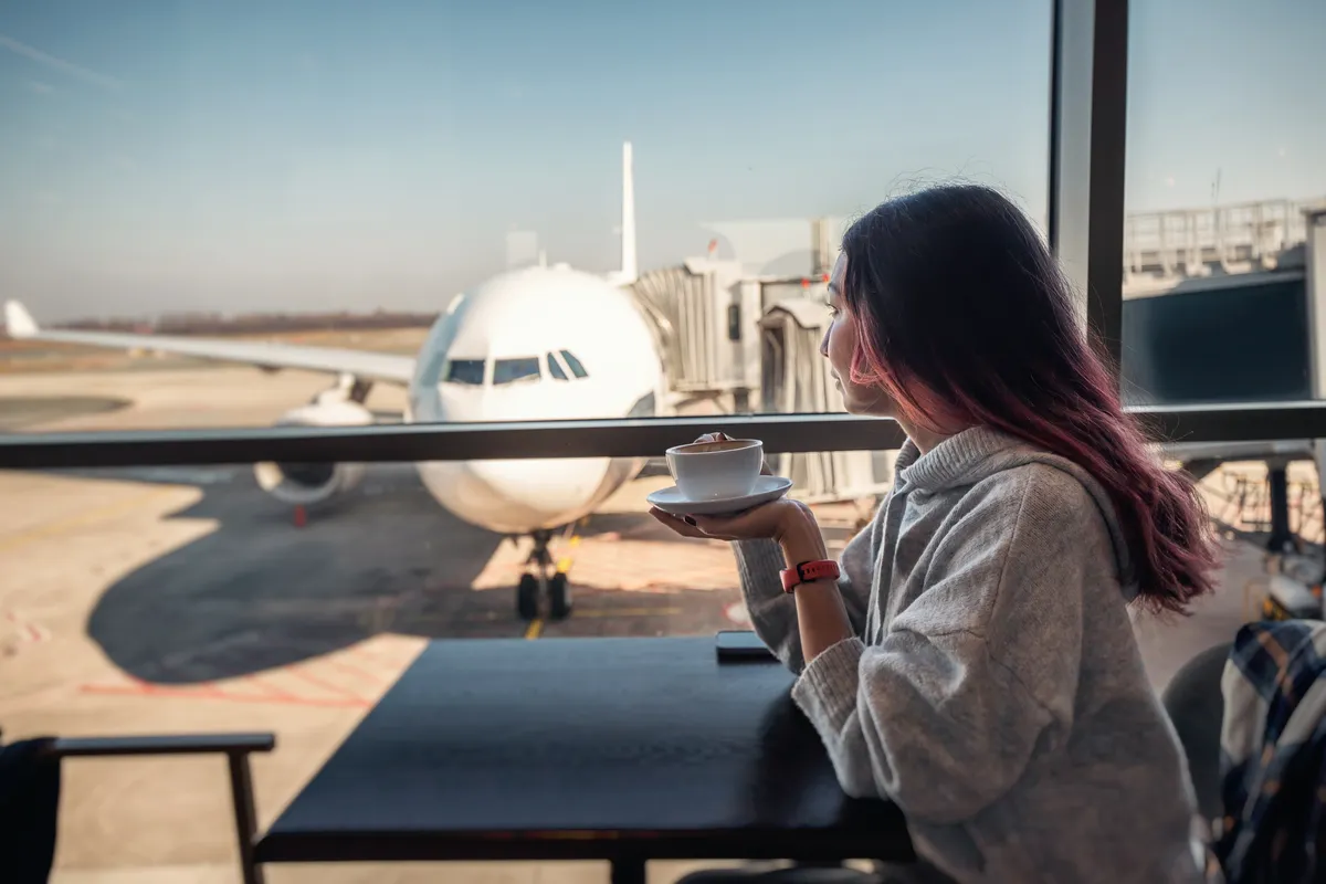 Passenger with a coffee in an airport lounge